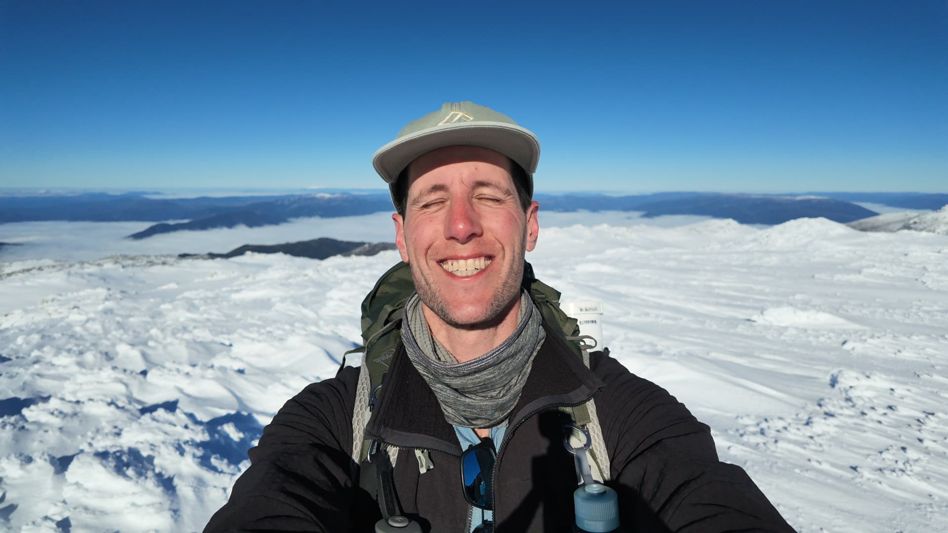 Sean Vitorovic on a snow-covered summit above the clouds